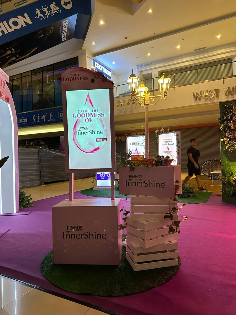 Large wooden block tower beside a touchscreen at a BRAND'S InnerShine activation