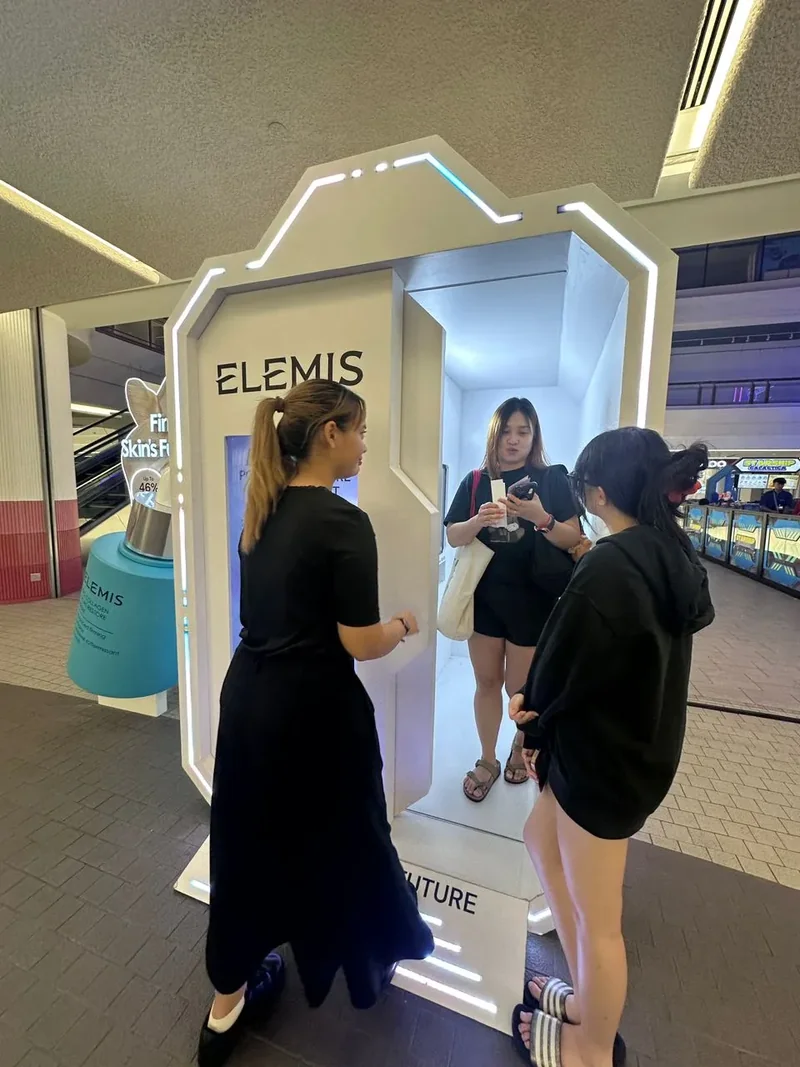 Guests and an attendant at the Elemis photobooth entrance